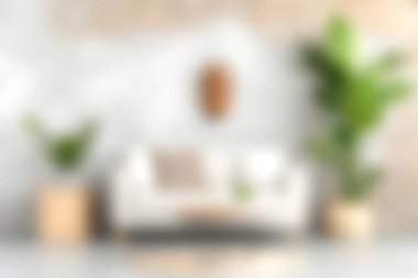 Yeşil yemyeşil bitkilerle çevrili şık bir kanepenin olduğu rahat ve modern bir oturma odası. Parlak alan rahatlama ve konfor için tasarlandı, çağdaş dekorlar ve doğal elementler sergileniyor..