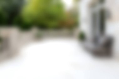 Bu resim, sakin bir açık hava alanının bulanık bir görüntüsünü tasvir ediyor, yeşil ve yumuşak bir ışık, rahatlama için mükemmel bir atmosfer yaratıyor..