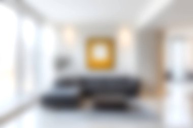 Rahat siyah bir kanepe ve sanatsal bir duvar dekorasyonunun olduğu, parlak doğal ışıkla aydınlatılmış, davetkar ve şık bir atmosfer yaratan modern bir oturma odası..