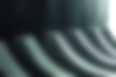 Şehir ortamında modern tasarım ve minimalist mimariyi vurgulayan, eğri büğrü beton şekiller ve gölgeler gösteren ilgi çekici soyut bir görüntü..