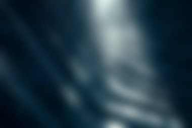 Metalik bir yüzeyde dramatik gölgeler ve yansımalar gösteren mimari çizgilerin ilgi çekici soyut görüntüsü, derinlik ve modernlik duygusunu çağrıştırıyor..