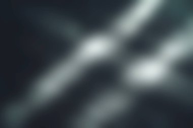 Bu soyut görüntü, tasarım projeleri ve sanatsal arka planlar için modern bir estetik sunan, dokulu karanlık bir yüzeyde dinamik ışık çizgileri sergiliyor..