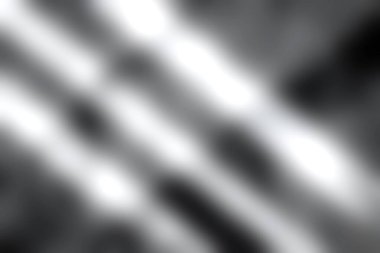 Bu resim gölgelerin ve ışığın desenli beton yüzeyde oynadığı ve çarpıcı desenler oluşturduğu bir oyun sergiliyor. Tek renkli tonlar derinliği ve kontrastı vurgular.