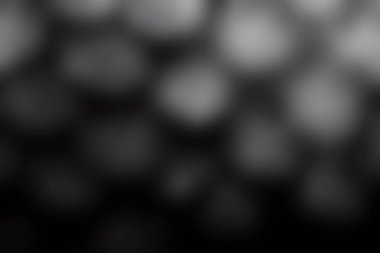 Yuvarlak siyah bir yüzeydeki su damlacıklarının yakın çekimi soyut ve rahatlatıcı bir siyah beyaz görsel etki yaratıyor. Görüntü huzur ve güzelliği iletir..