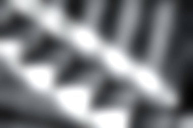 Bu çarpıcı siyah-beyaz görüntü geometrik gölgeli ve dokulu yüzeyli bir merdiven yakalıyor, minimalizmi ve derinliği vurguluyor..