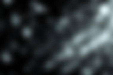 Karanlık bir zemin üzerinde su damlacıklarının büyüleyici yakın plan görüntüleri ışık ışınları ve yansımalarla büyüleyici bir bokeh etkisi yaratıyor. Sanatsal projeler için mükemmel..