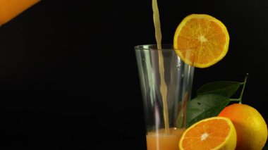 Buzlu bir bardak portakal suyu, bir dilim portakal ve tarçın.