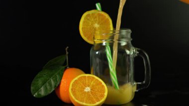 Bardakta portakal suyu ve masada pipet.