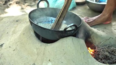 Hintli bir kadın çamur sobasında pilav yapıyor. Hint köyü manzarası.