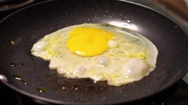 Çiğ yumurta ve tava. Kızarmış yumurta kızartma tavasında, yakın çekim. Kahvaltıda yumurta..