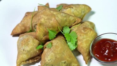 Domates soslu Hint samosası, yeşil biber ve kişniş yaprağı. Patates püresi ve baharatla doldurulmuş lezzetli ve çıtır samosalar..