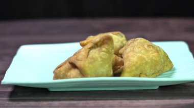 Domates soslu bir masada servis edilen Hint samosası..