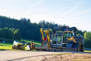 Kırsal alana park edilmiş ağır yol yapım ekipmanları. Almanya, Bavyera 'da altyapı gelişimi.