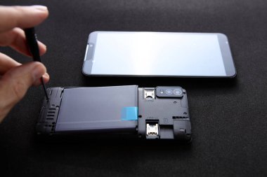 Bir akıllı telefon koyu arkaplan üzerinde ayrık bir ekran ile açıldı. Konsept, telefon ekranı değişimi ve profesyonel onarım hizmetini temsil ediyor.