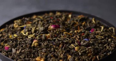 Değişim etkisiyle dönen yeşil çay yapraklarının makro döngü videosu. Görünür gül yaprakları ve bitkiler doğal renk paleti ile zengin organik dokular oluşturur..