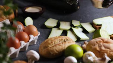 Bir şefin dilimlenmiş kabağın üzerine limon, çörek, maydanoz ve yumurta serptiği bir kamera videosu..