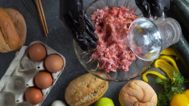 Şefin ellerini su eklerken ve kristal kasede baharatla karıştırırken gösterilen yassı bir video. Mantar, limon, çörek, maydanoz, yumurta ve kabak..