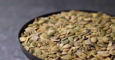 Makro yakın çekim video yumuşak eğim kaydırma bulanıklığı ile dönen kabak çekirdekleri göstermektedir. Doğal yeşil tonlar ve gerçekçi doku tasarım veya sunum için temiz organik zemin oluşturur.