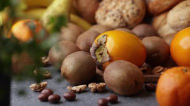 Yumuşak bir kaydırma videosu. İçinde hurma, kivili hamur işi, fındık ve maydanoz var. Tahta bir tabağa konmuş sıcak yemek kompozisyonu..