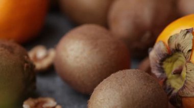 Yakından çekilen, hurma, kivi, fındık ve maydanozu ahşap bir tabakta sımsıkı yerleştiren bir video..