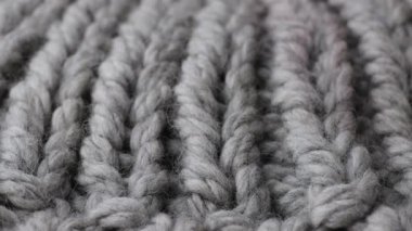 Görünür lifler ve yumuşak sıcak aydınlatmayla kalın yün örgü kumaş içeren bir makro kaydırma videosu..