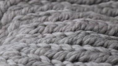Yumuşak lifleri ve hafif yayılmış ışık altında el işi dokusunu ortaya çıkaran, kalın yün örgü kumaşı yakından gösteren yavaş bir video..