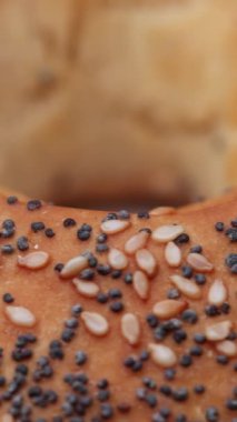 Tohumlu bir bagel çöreği ayrıntılı bir makro görünümde döner ve temiz gıda bağlamında kusursuz bir döngü olarak gösterilir..