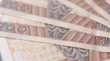 200 zloti banknottan oluşan bir makro rotasyon, basılı dokuyu, yüzey liflerini ve para biriminin detaylarını kusursuz bir döngüde gösteren fanatik bir düzende yayılmış..