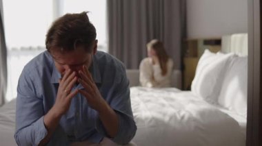 Stresli adam eşiyle mali sorunlar ve ödenmemiş faturalar hakkında tartışıyor, aile bütçesi krizi, para baskısı, borç stresi, evdeki ekonomik zorlukların neden olduğu duygusal gerilim