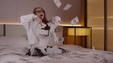 Neşeli nüfuzlu bir kız havadan para saçıyor, banknotları havaya atıyor, çevrimiçi iş başarısını kutluyor, büyük kar, pasif gelir, modern yaşam tarzı, zenginliğin tadını çıkaran zengin kadın, havadaki dolar.