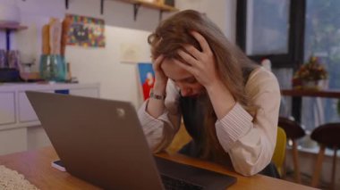 Hüsrana uğramış genç iş kadını dizüstü bilgisayarı üzerinde çalışırken stres ve yorgunluk yaşıyor, sorunlarla boğuşuyor, şiddetli bir baş ağrısı çekiyor ve neredeyse profesyonel olarak tükeniyor.