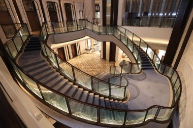 Görkemli çok katlı lobi süpürücü, cam parmaklıklı modern spiral merdiven ve aydınlatma desenli paneller, farklı lüks binalara açılıyor.