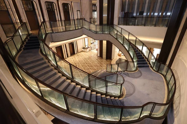 Görkemli çok katlı lobi süpürücü, cam parmaklıklı modern spiral merdiven ve aydınlatma desenli paneller, farklı lüks binalara açılıyor.