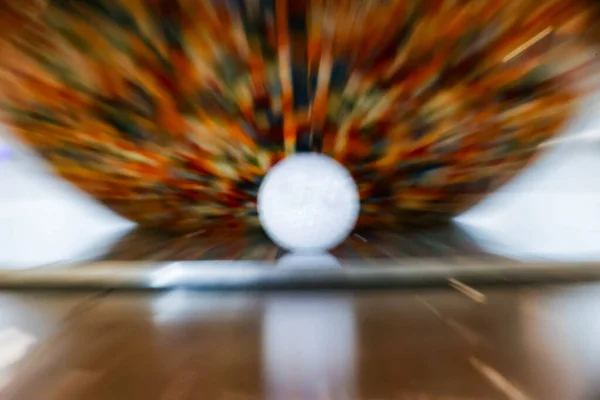 Çarpışma anında güçlü hareket bulanıklığı ile yakalanan golf topu, profesyonel golf antrenmanında güçlü vuruşu, hızı, odaklanmayı ve hassasiyeti sembolize eder.