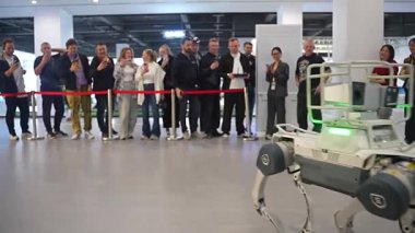 Şangay 8 Ocak 2026 gelişmiş dört ayaklı robot köpek teknoloji fuarında yürüyor. Seyirciler, yenilikçi makineyi akıllı telefonlarıyla filme alıyorlar.