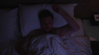 Sıkıntılı bir adam korkunç bir kabustan aniden uyanıyor. Korku, panik, endişe dolu karanlık bir yatak odası var. Elini yüzüne koymadan önce korkunç bir kabustan korkuyor.