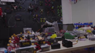 İnsansız hava aracı ekipmanları, parçaları, araçlar, FPV teknolojisi, mühendislik, insansız hava aracı araştırma ve geliştirme projeleri için devre montajı gösteren elektronik atölyesi çalışma tezgahı