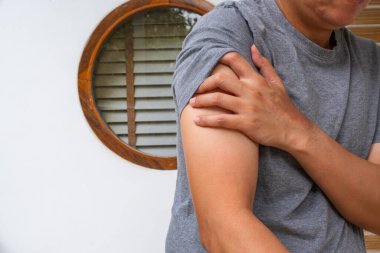 Asyalı adamın kolunda kol ağrısı, kas gerginliği ya da sinir gerilimi belirtisi var. Ortopedi, fizik tedavi ya da ağrı kesici reklamları için ideal..