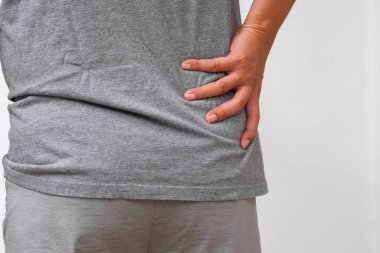 Asyalı adamın belinde bel ağrısı, bel ağrısı, kas zorlanması ya da sinir gerilimi belirtileri var. Omurga bakımı veya ortopedik reklamlar için ideal..