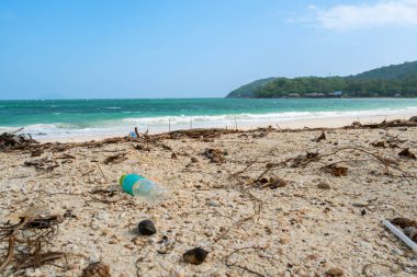 Plastik atık, kumlu kıyı şeridine kirliliği, iklim etkisini ve acil okyanus koruma çağrısını hatırlatıyor..
