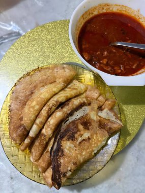 Kızarmış balık, bir kase baharatlı sosla servis edilir.