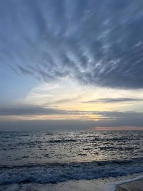 Gün batımında bulutların oluşturduğu barışçıl okyanus dalgaları