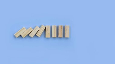 Tahta dominolar düşüyor. Domino etkisi güçlü bir domino taşı tarafından durduruldu. Sigorta, iş, risk, yönetim kavramı.