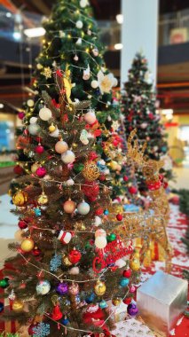 Süslü Noel ağacında asılı renkli Noel süslerinin yakın çekimi.