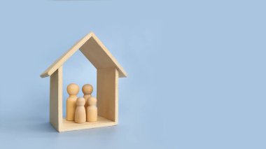 Ahşap aile ve ev figürleri ile aile koruması ve ev güvenliği kavramı.