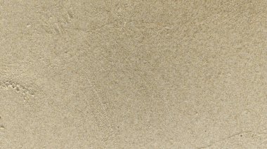 Kumsal yüzeyi. Sakin, deniz kenarı havasını, yaz tatilini ve kıyı dokusunu temsil eden minimum doğal altyapı.