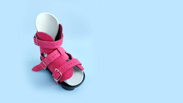 Top view of orthopedic boot for infant clubfoot treatment, highlighting straps and medical design.