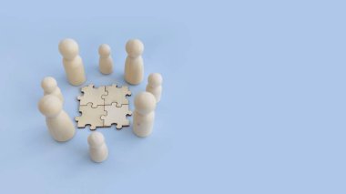 Takım çalışmasını, grup tartışmasını ve işbirlikçi planlamayı gösteren bulmaca parçalarının etrafındaki ahşap figürler grubu.