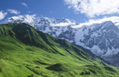 Zümrüt yamaçları ve sarp dağ zirveleri ile dağ manzarası