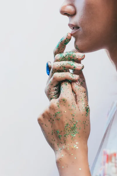 Mirada pensativa de las mujeres jóvenes con brillo en las manos — Foto de Stock